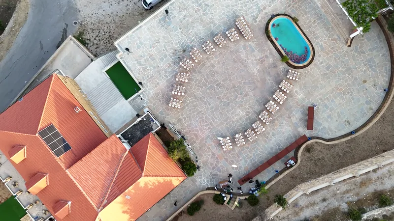 The courtyard from directly above: chairs in a ring, the pool and the red roof